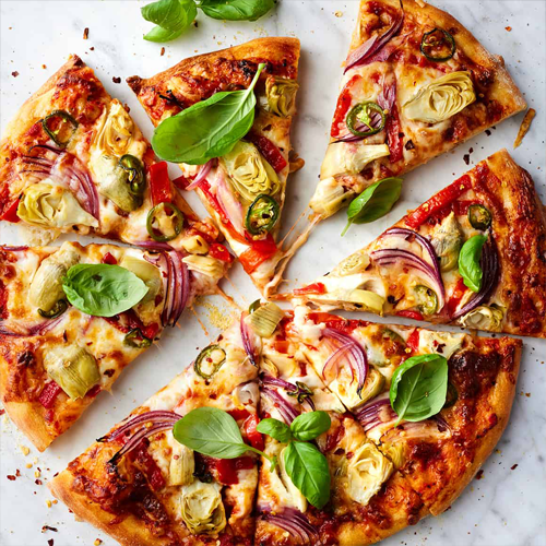 Fresh artisan pizza topped with herbs and vegetables