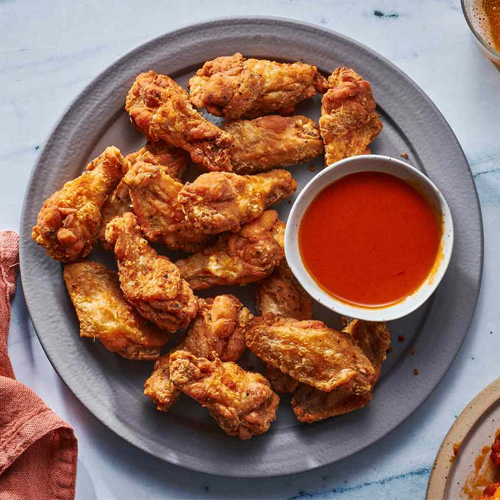 Crispy golden wings served with house hot sauce